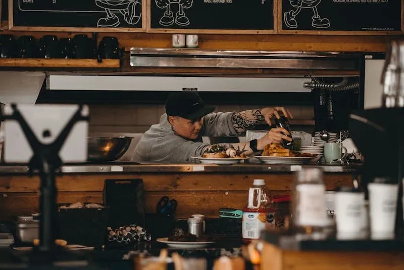 An EATology chef plating a dish in the kitchen